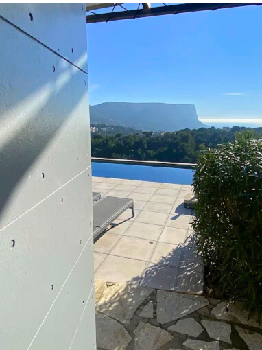 rendu final avec la vue imprenable sur la mer et les volets CTBX fraîchement posés. L’association des volets bois et de la façade claire donne à la maison un charme authentique et élégant.